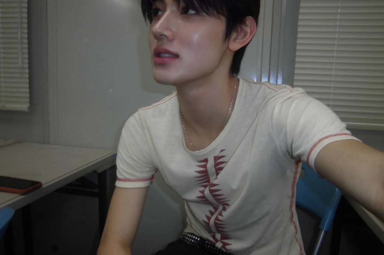 Seated in a white tee, looking away from the camera
